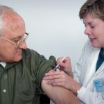 woman injecting syringe on mans arm