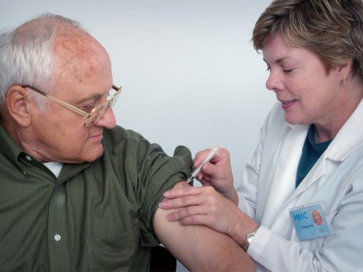 woman injecting syringe on mans arm