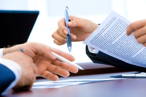 Kleine ondernemer die administratie en facturen doorneemt aan een bureau