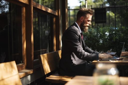Persoon die op een laptop werkt in een café tijdens een lunchpauze