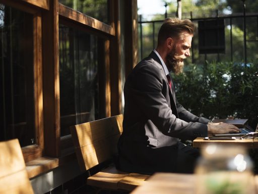 Persoon die op een laptop werkt in een café tijdens een lunchpauze