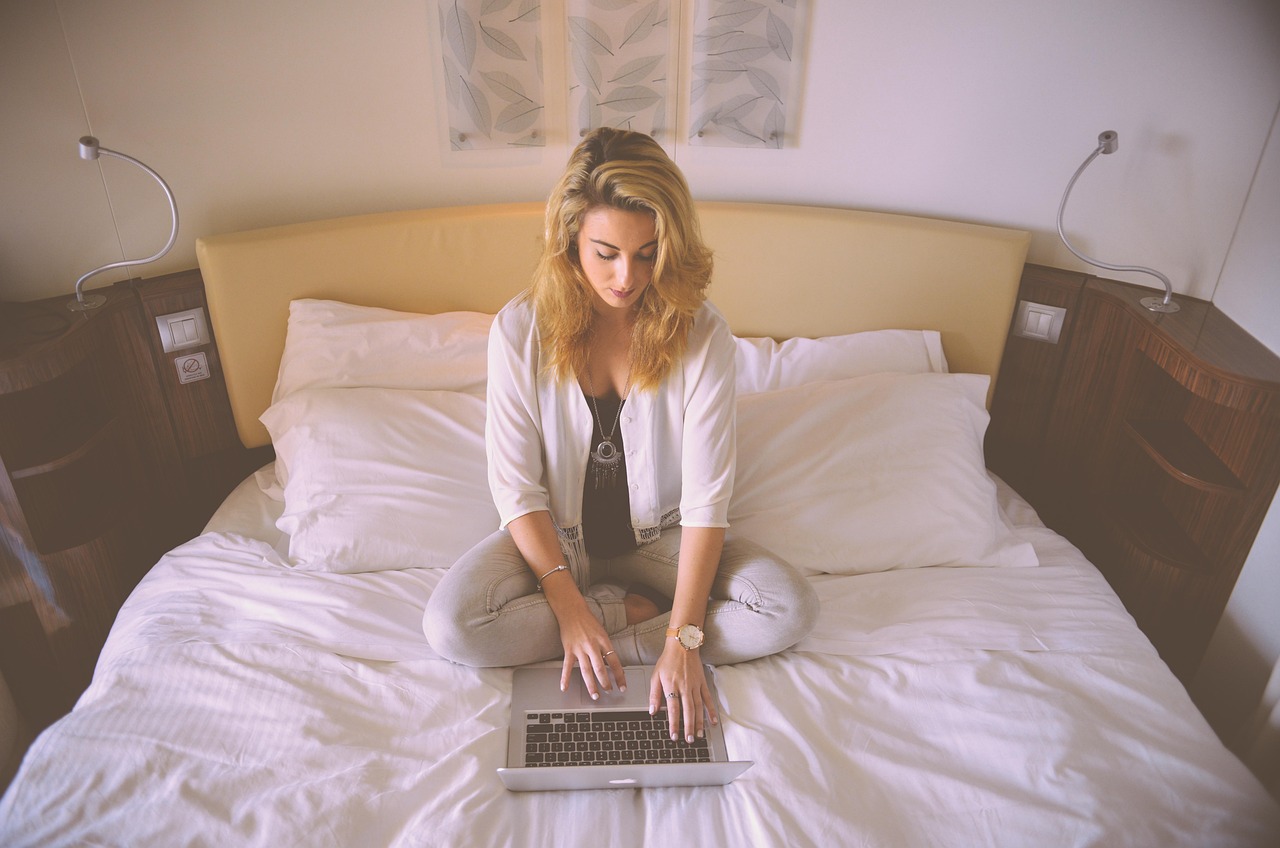 Persoon die thuis op een laptop werkt terwijl hij zijn internetabonnement vergelijkt