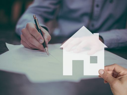 Huizensleutels naast een koopcontract op een bureau