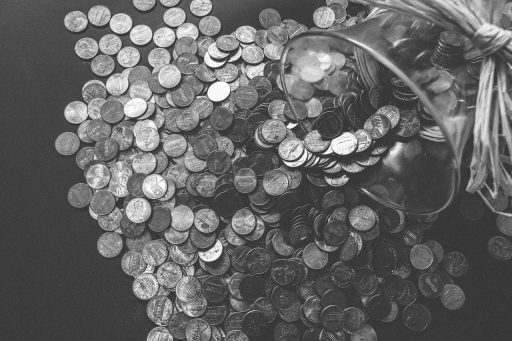 Spaarpot naast een glas met muntgeld als symbool voor sparen en vastzetten van geld