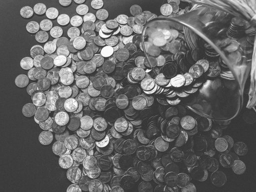 Spaarpot naast een glas met muntgeld als symbool voor sparen en vastzetten van geld