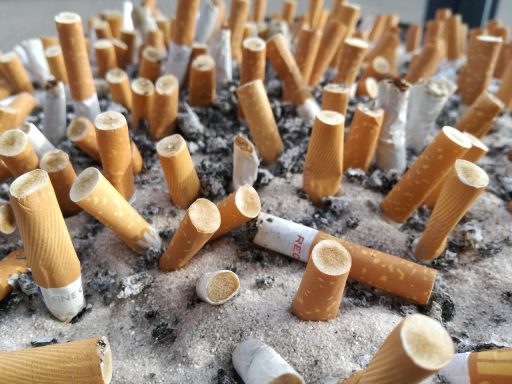 Een pakje sigaretten naast stapels euromunten en bankbiljetten